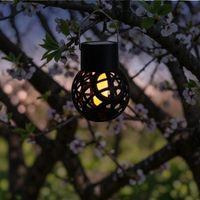 Solarlaterne Windlicht hängt in einem Kirschbaum bei Abend und leuchtet